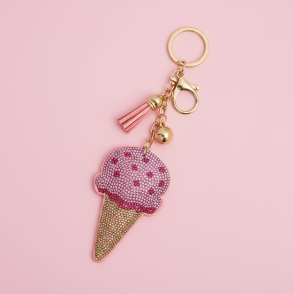 Ice cream cone keychain with pink top and gold base on a pink background