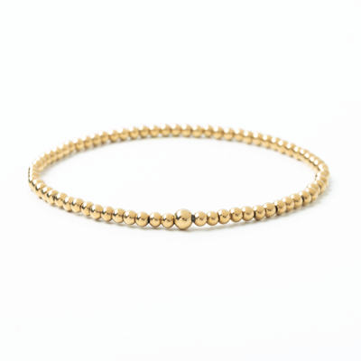 Gold beaded bracelet on a white background
