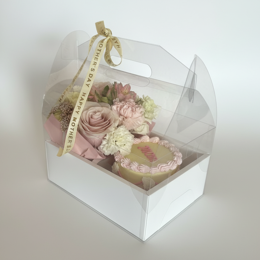 Mother's Day gift box with flowers and a MOM cake on a light surface