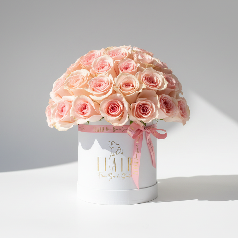 Bouquet of pink roses in a white box on a light gray background