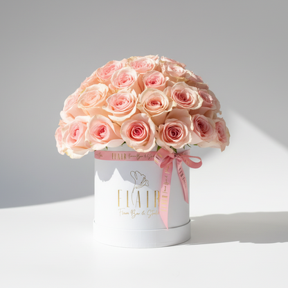 Bouquet of pink roses in a white box on a light gray background
