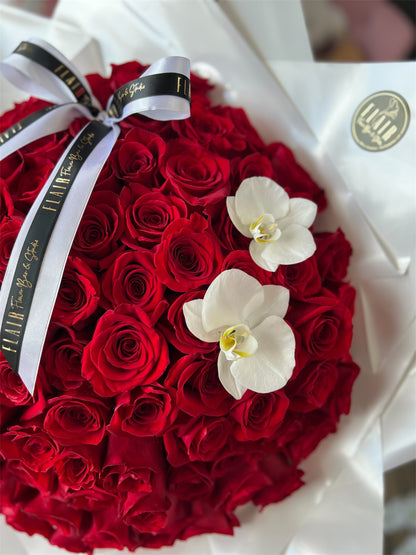 Bouquet of red roses with white orchids and a gold ribbon on a white background