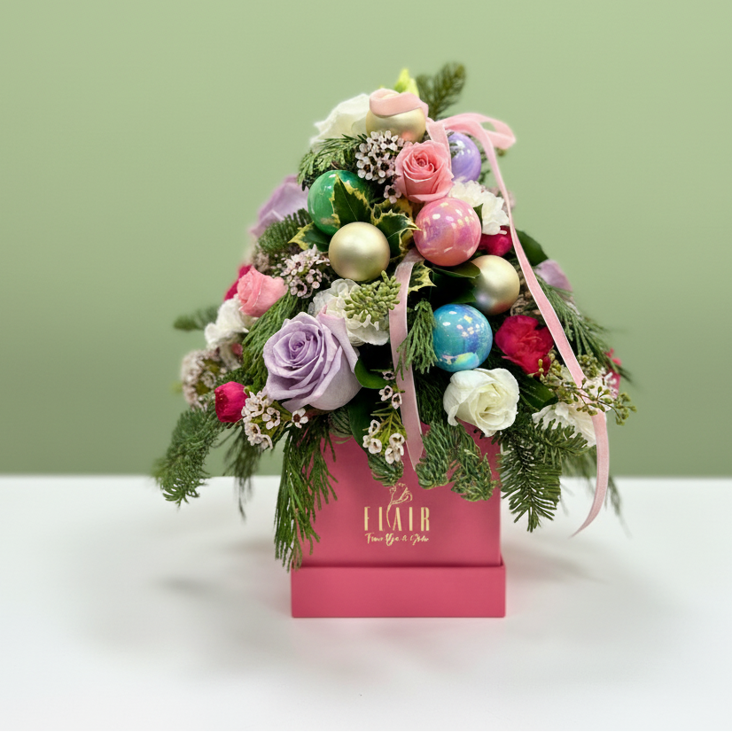 Decorative flower arrangement with colorful ornaments in a pink box on a light green background