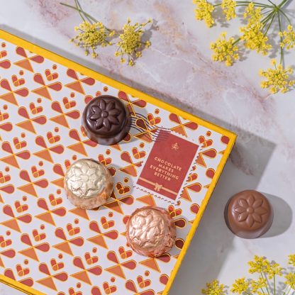 Chocolates on a decorative box with yellow flowers on a marble surface