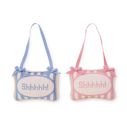 Two small pillows with 'Shhhhh!' text, one blue and one pink, on a white background.