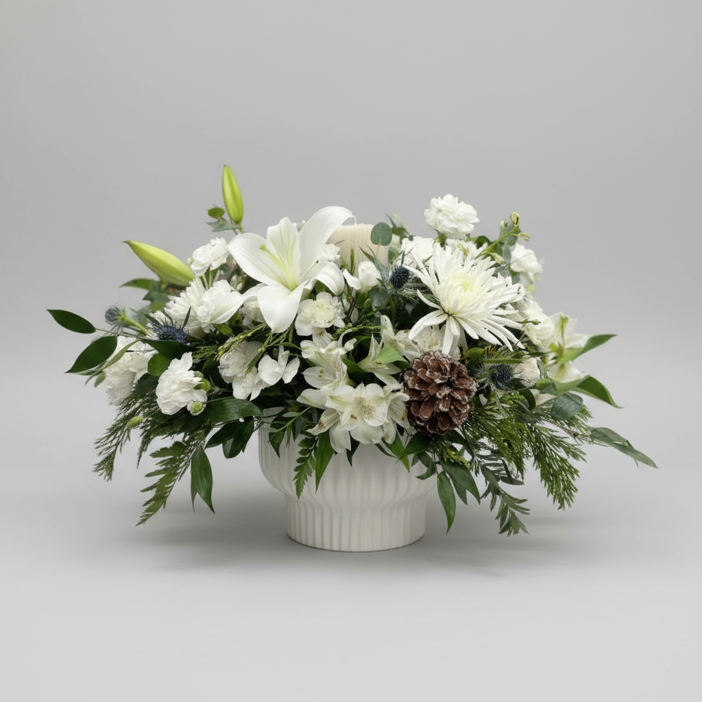 Floral arrangement with white flowers and greenery in a white vase on a light gray background
