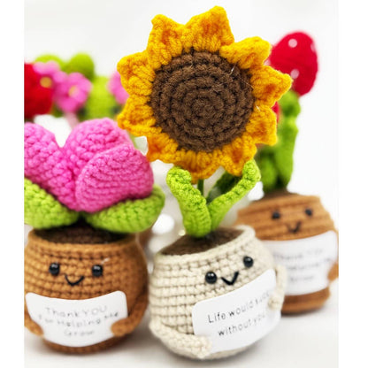 Crocheted flower pots with smiling faces on a white background