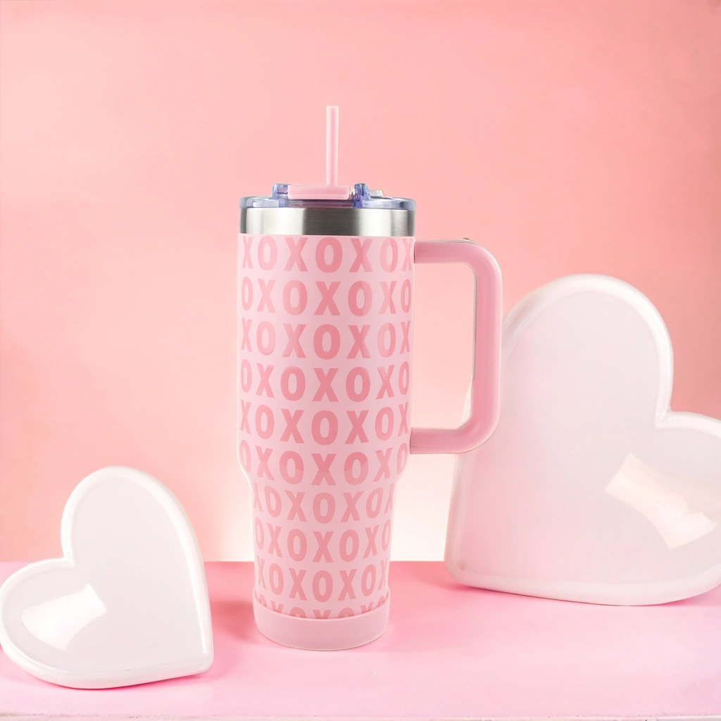 Pink tumbler with 'XOXO' pattern on a pink background with heart-shaped objects.