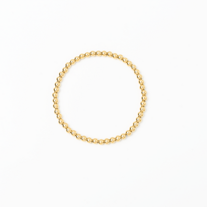 Gold beaded bracelet on a white background