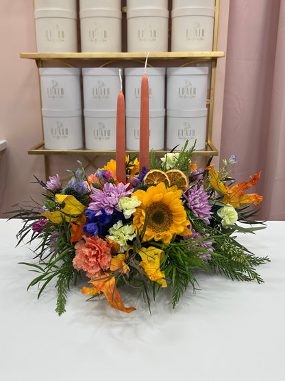Autumn floral centerpiece with sunflowers, purple and orange blooms, and two taper candles, by Flair Flower Bar in Northern Kentucky